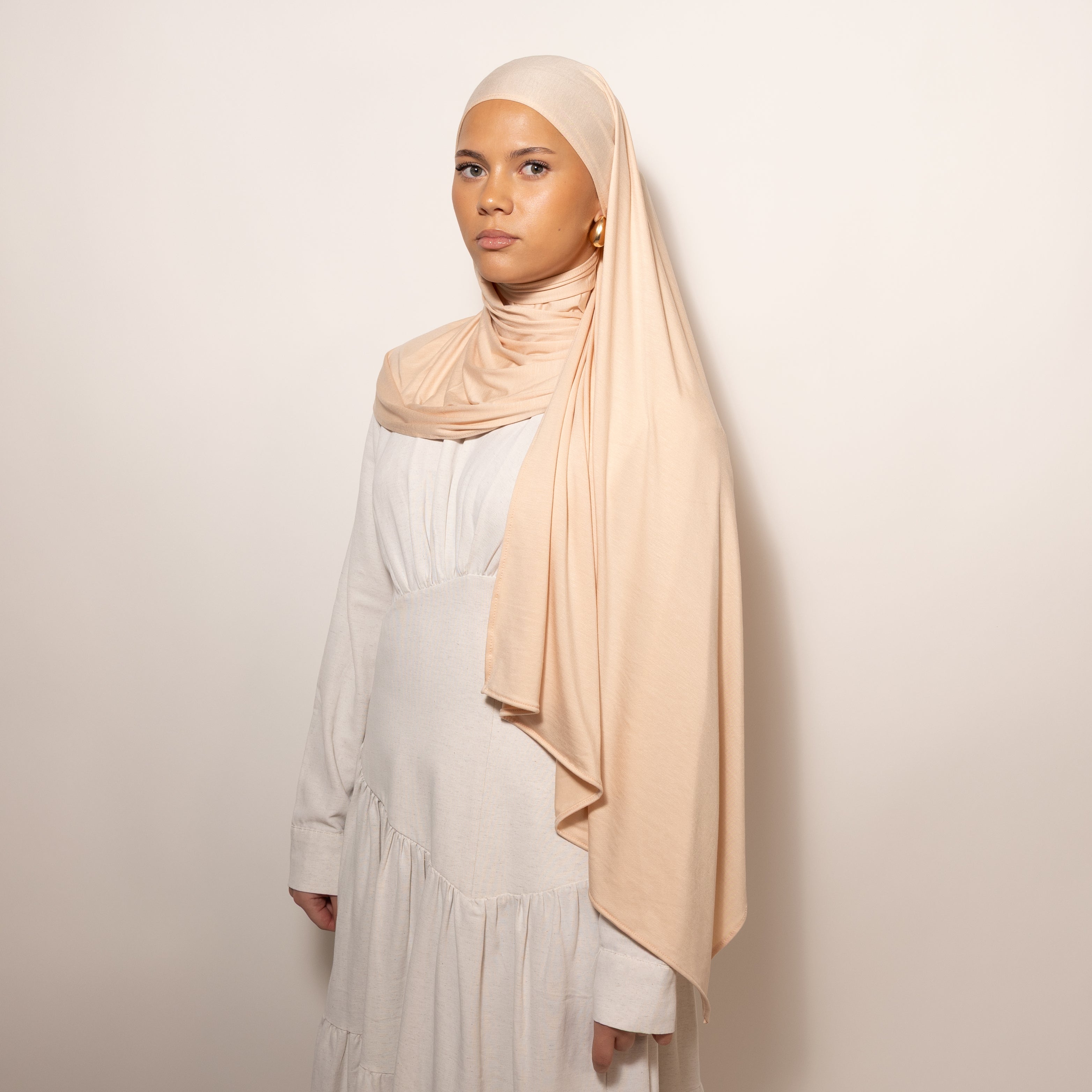 Nainen puettuna tyylikkääseen vaaleaan Bamboo Jersey Peachy Sand Hijab huiviin