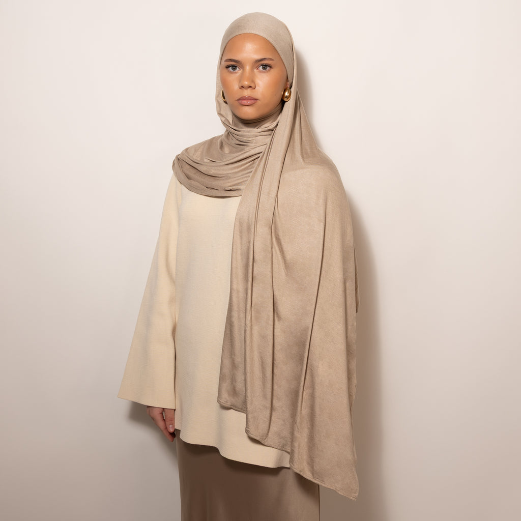 Nainen puettuna tyylikkääseen vaalean sävyiseen Cotton Jersey Sandstone Hijab huiviin