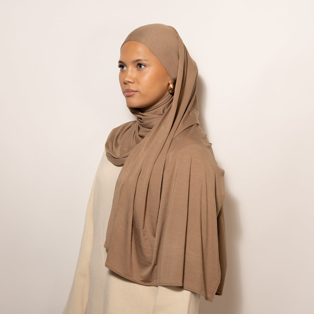 Nainen puettuna tyylikkäästi Bamboo Jersey Deep Sand Hijab huiviin