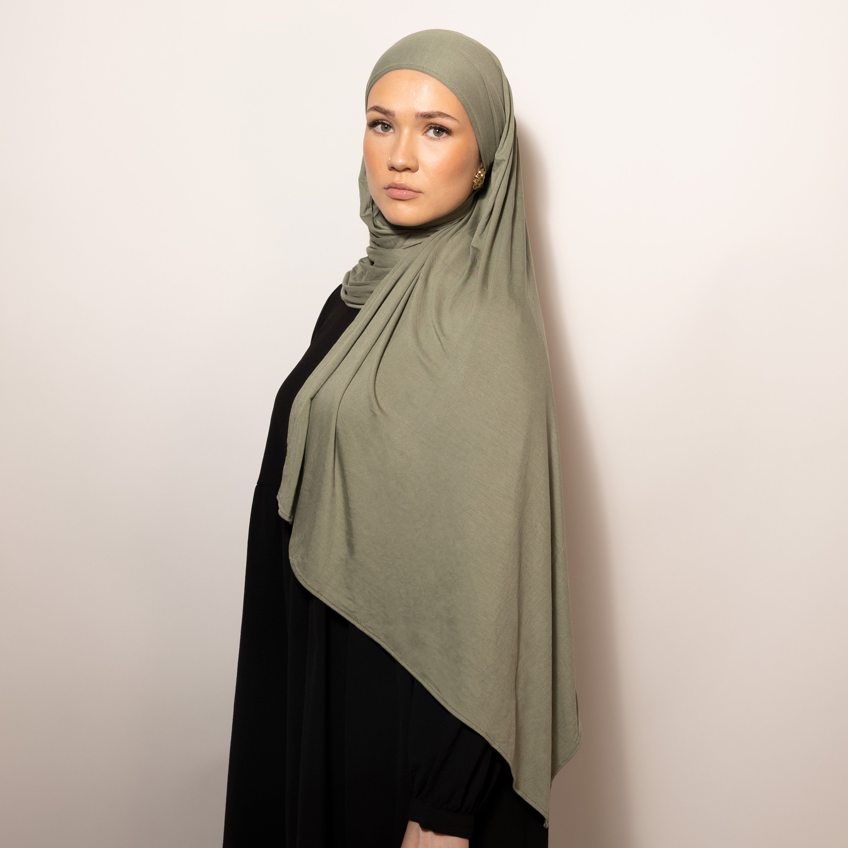 Nainen puettuna tyylikkääseen vihreään Bamboo Jersey Dusty Olive Hijab huiviin