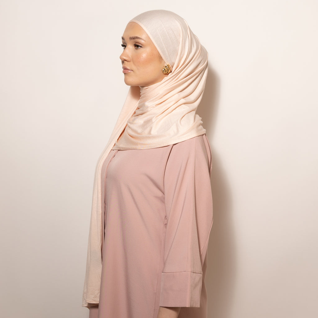 Nainen puettuna tyylikkääseen vaaleaan Cotton Jersey Light Blush Hijab huiviin